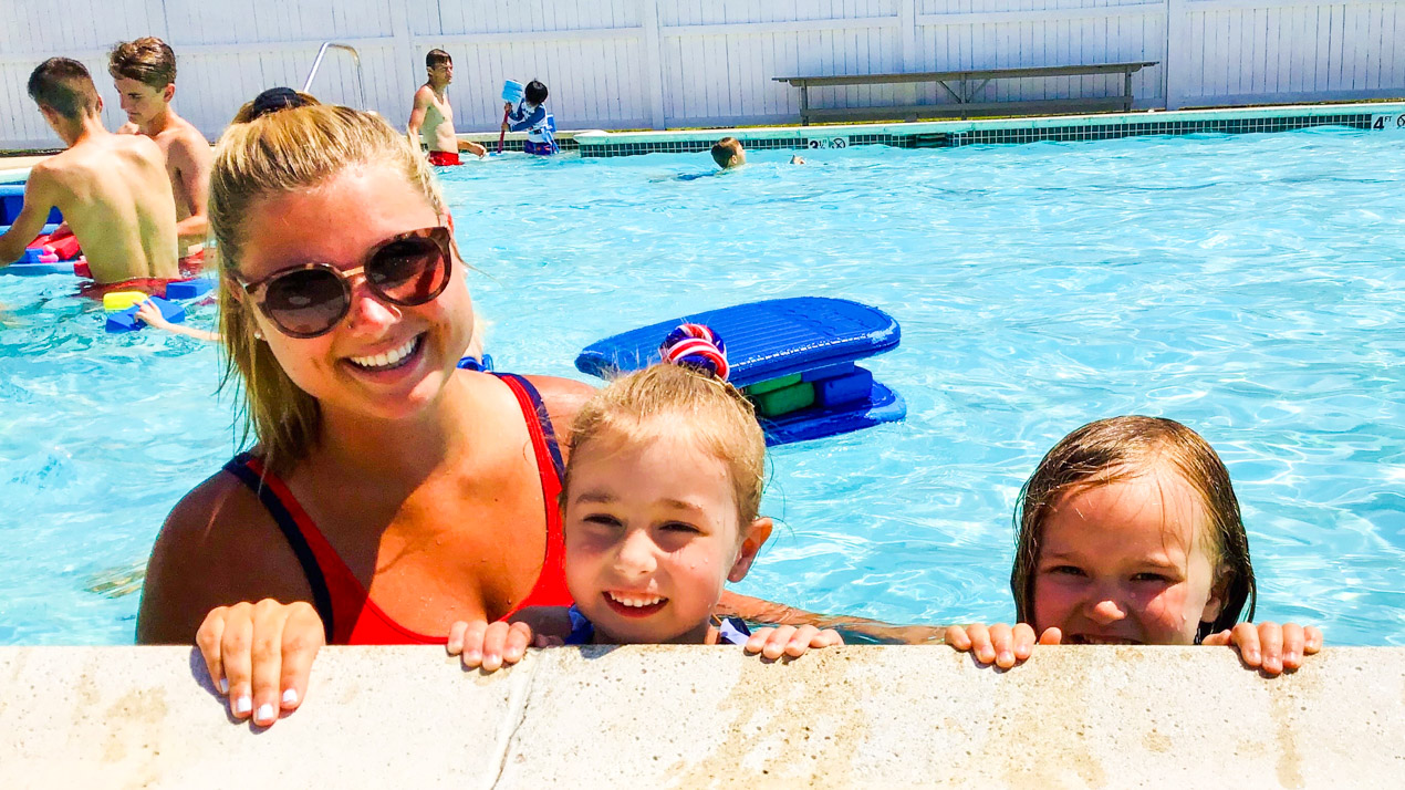 Female lifeguard with two girl campers in the pool